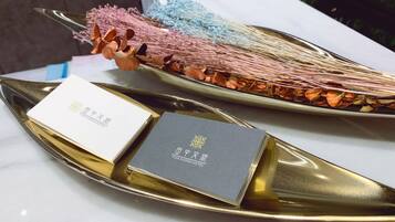 Una mesa con dos bandejas doradas, cada una con una tarjeta y un adorno.