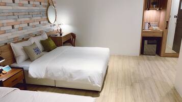 A hotel room with a bed, bedside table, and a small desk with a mirror.