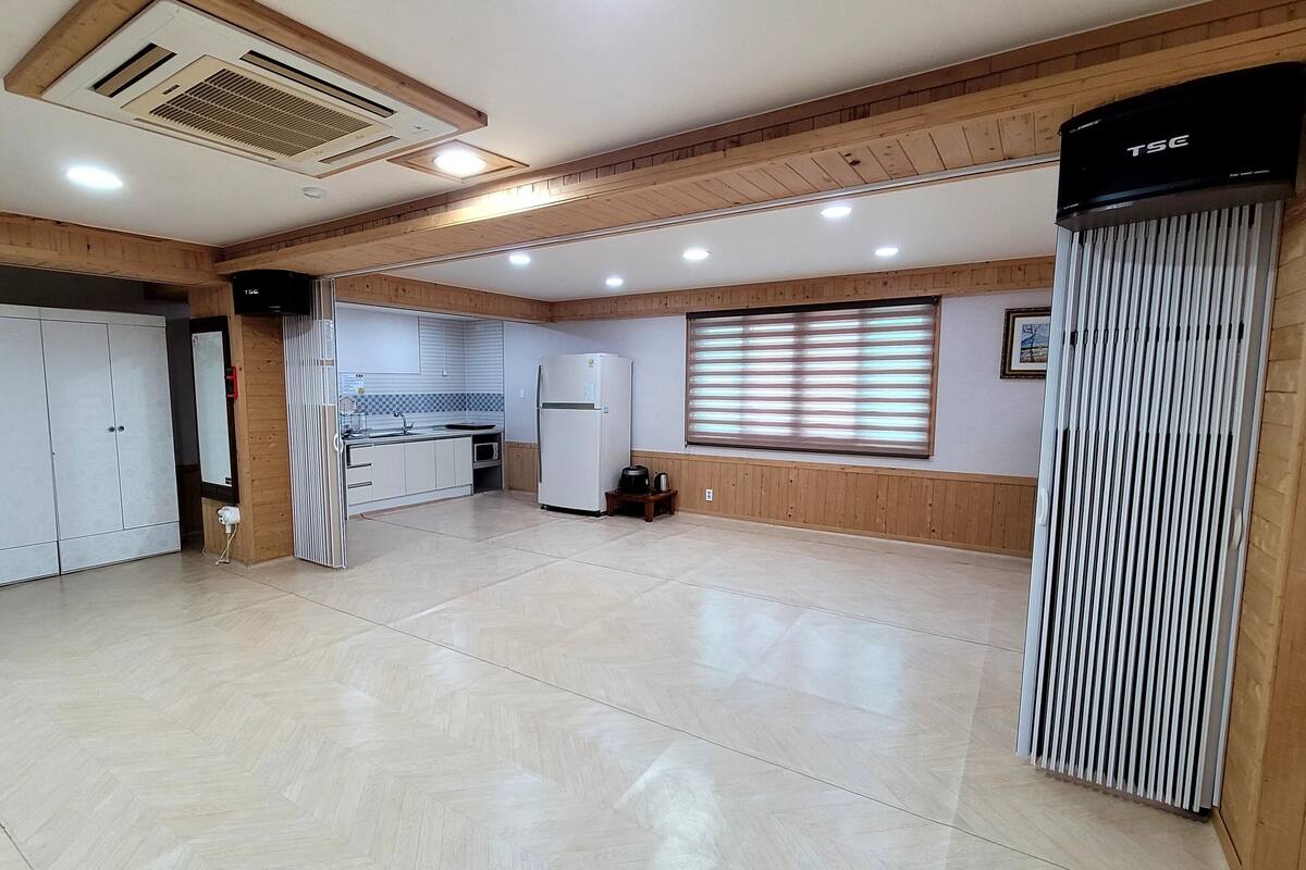 A spacious kitchen with a refrigerator, stove, and wooden cabinets.