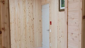 Ein Korridor mit Holzvertäfelung, einer weißen Tür und einem gerahmten Bild an der Wand.