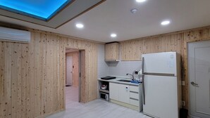Eine Küche mit Holzwandverkleidung, einer eingebauten Spüle, einem Kühlschrank und einem Oberlicht.