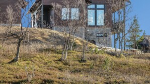 Ein modernes, zweistöckiges Haus mit einer breiten Veranda und einem überdachten Eingangsbereich.