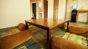 A dining area with a wooden table and four brown cushioned chairs. - Flying Yak Hotel - Hostel (Kathmandu)