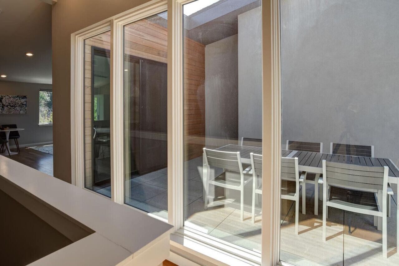 Un interior moderno con un ventanal que da a una zona de estar exterior.