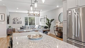 A modern kitchen with granite countertops, stainless steel appliances, and pendant lighting.