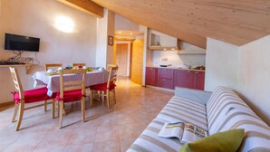 Une pièce confortable comprenant un coin repas, une kitchenette et un canapé.