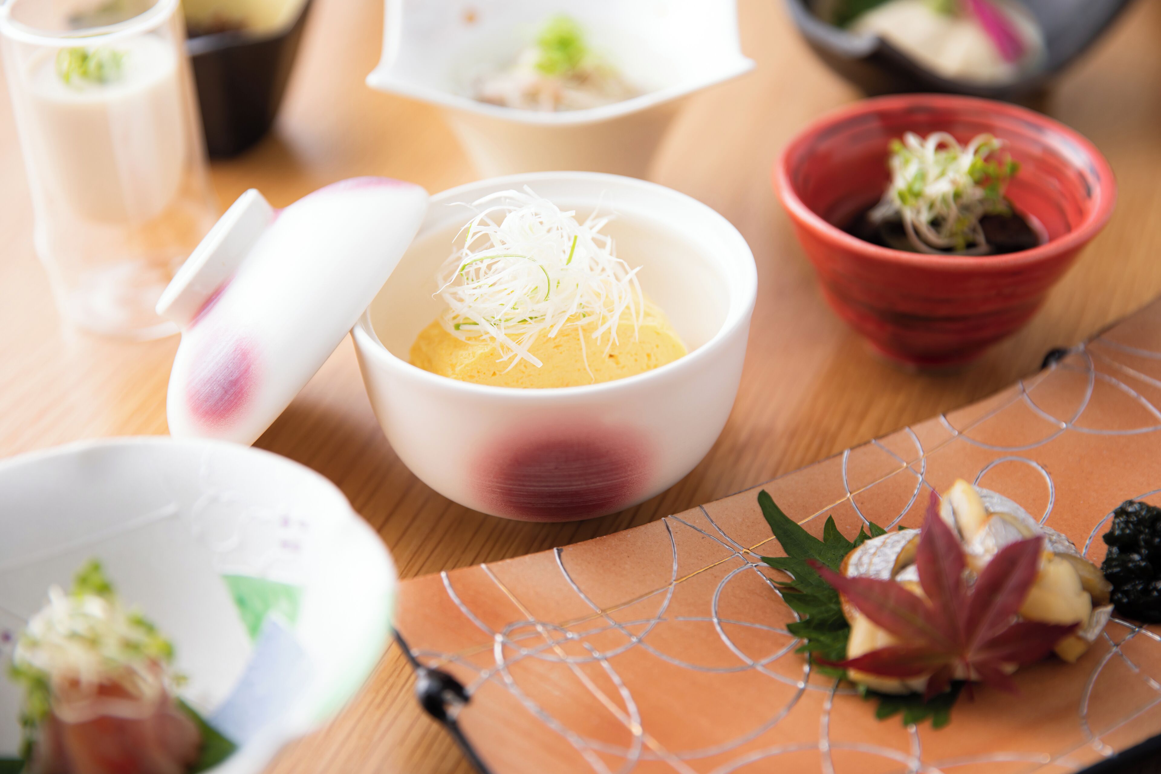 A variety of dishes with different garnishes and presentations on a wooden table.