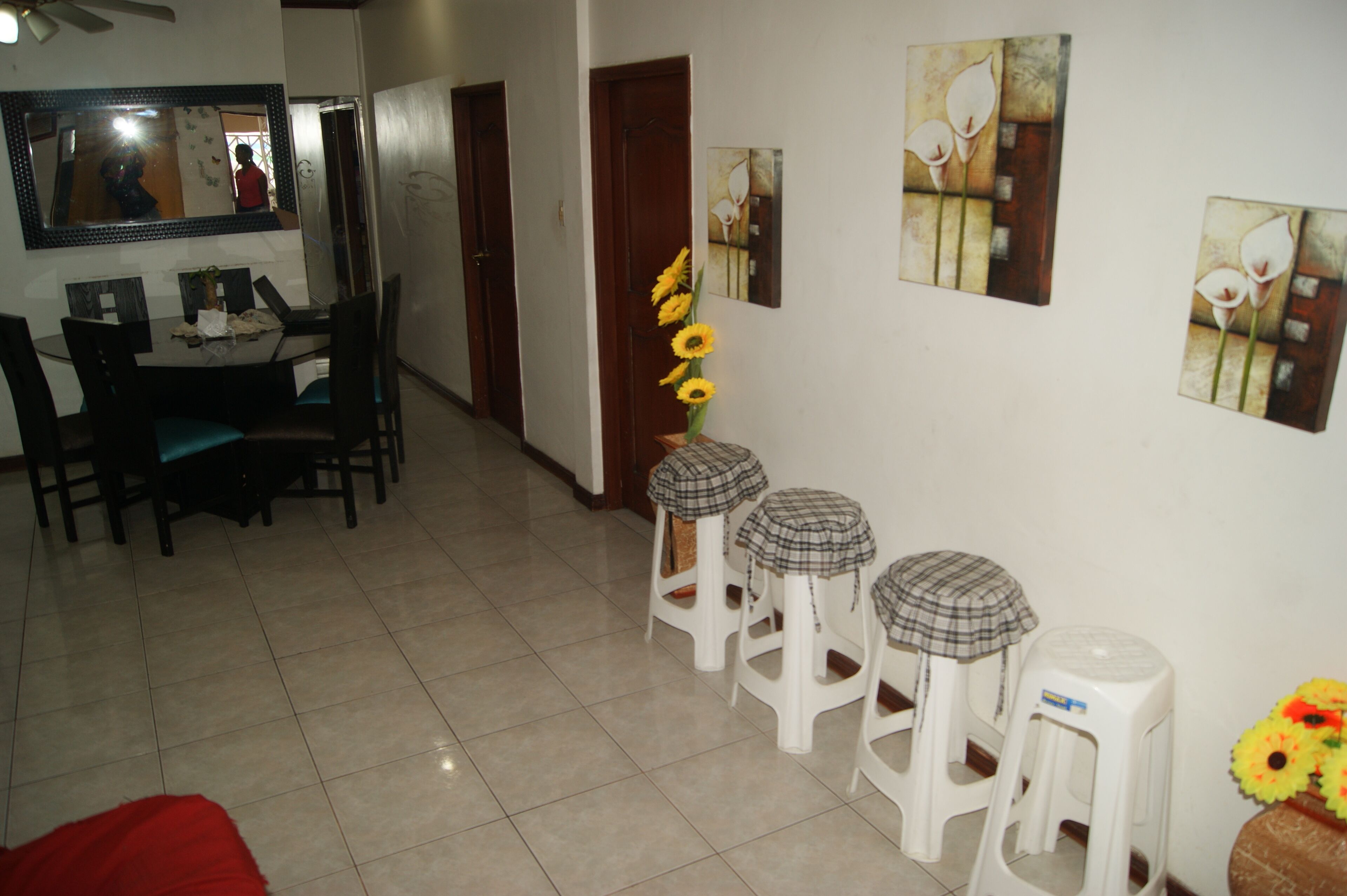 A dining area with a table and chairs, a mirror, and a hallway with doors.