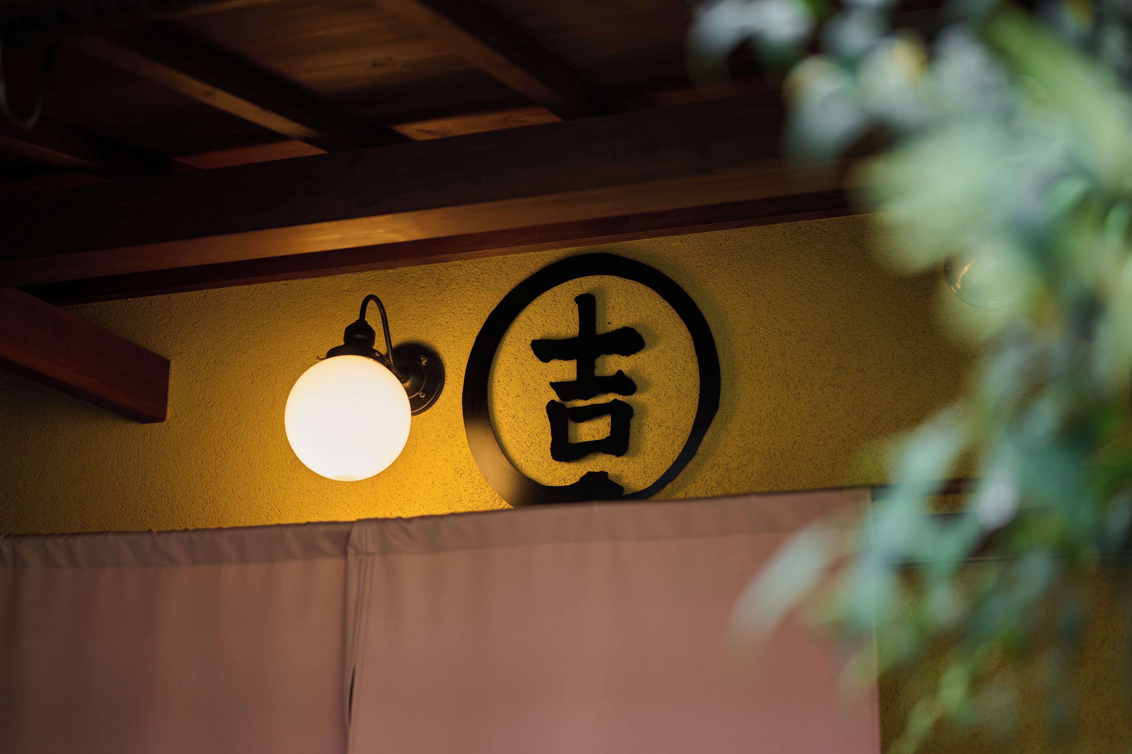 A wall with a circular sign and a hanging light fixture.