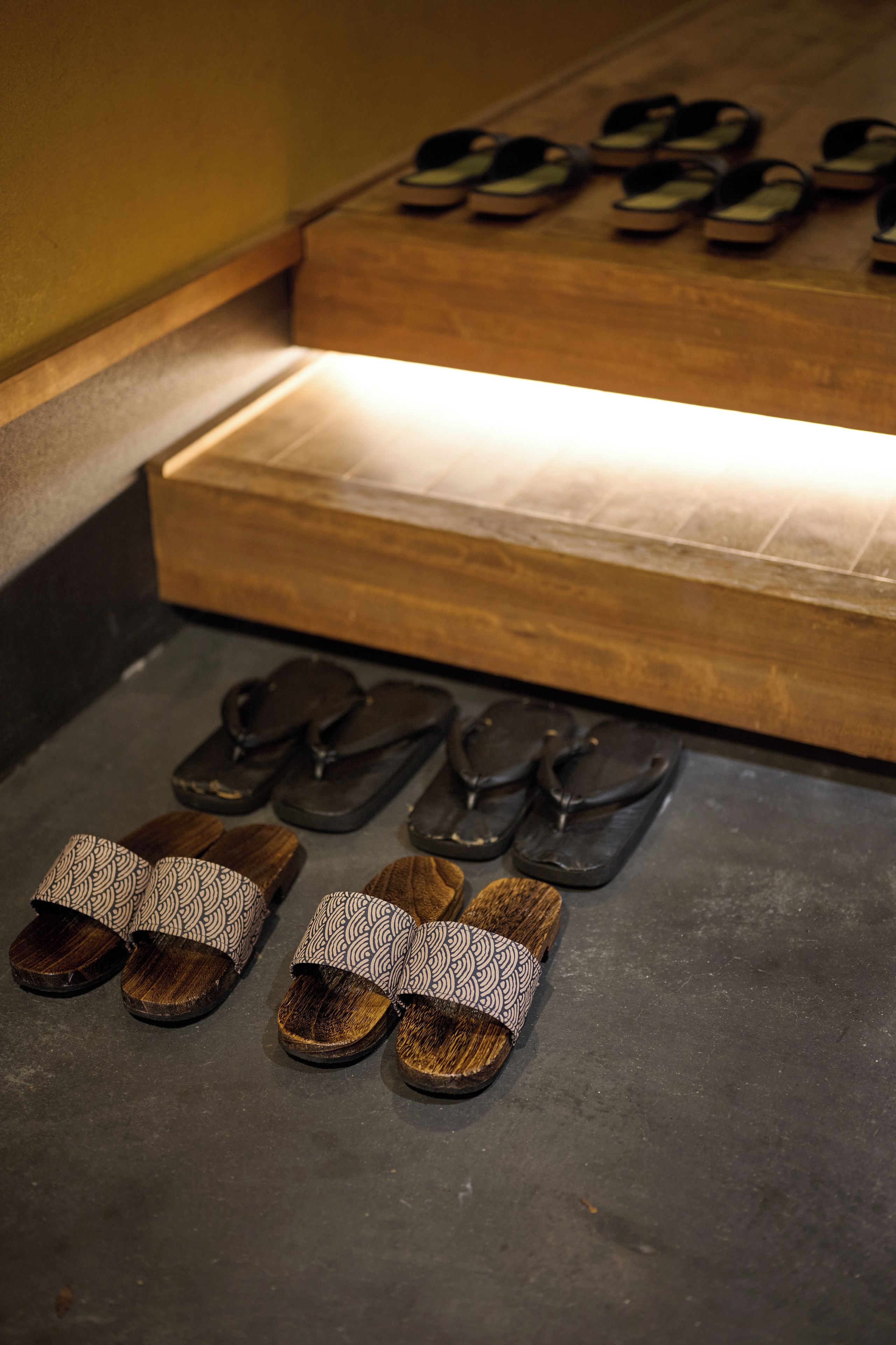 A display of sandals with a wooden base and a patterned fabric cover.