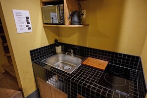 A kitchen with a sink, a microwave, and a stove. - Tsumugi Horikawakichimonji (Kyoto)