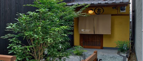 Un edificio japonés tradicional con fachada de madera, techo de tejas y un letrero que indica que es un restaurante.