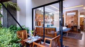 A modern room with a glass partition, wooden furniture, a bed, and a small kitchen area. - Araya Angkor Residence (Siem Reap)