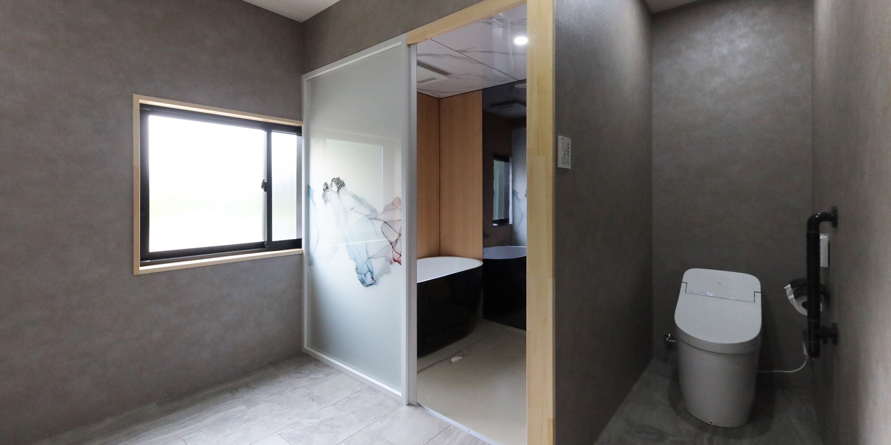 A modern bathroom with a toilet, a sink, and a window.