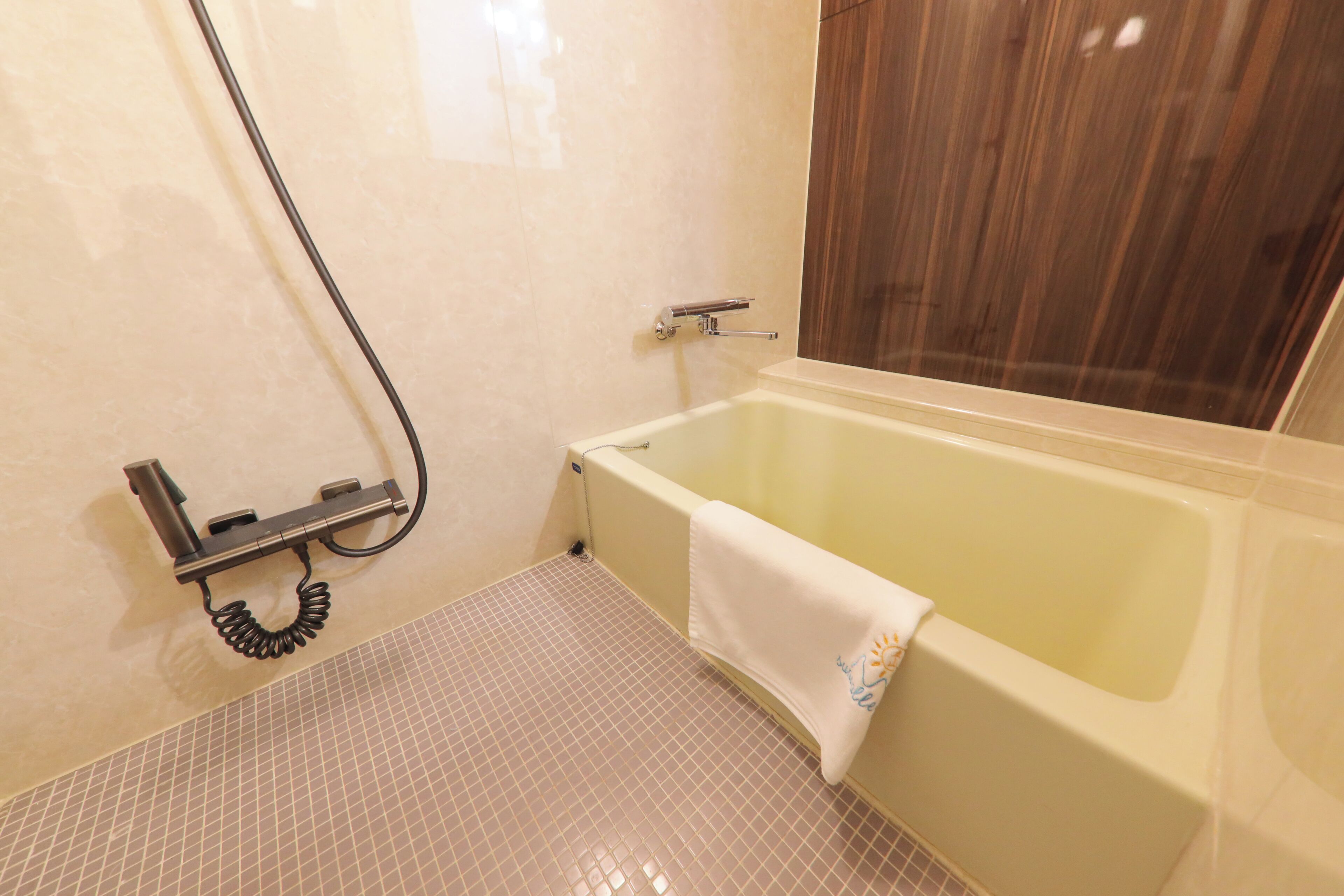 A bathroom with a bathtub, a shower, and a tiled floor.