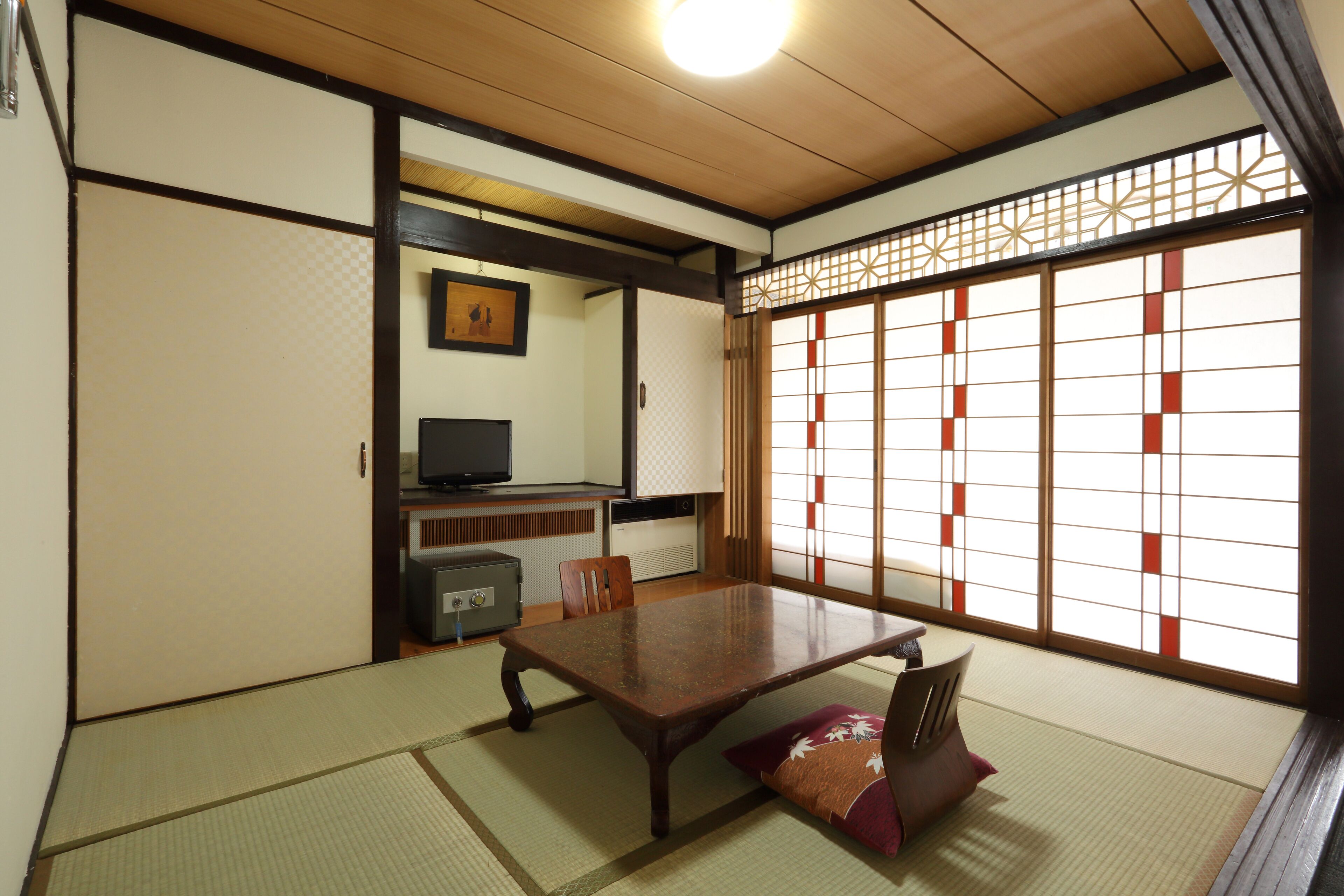 A traditional Japanese room with tatami flooring, a low wooden table, and sliding doors.