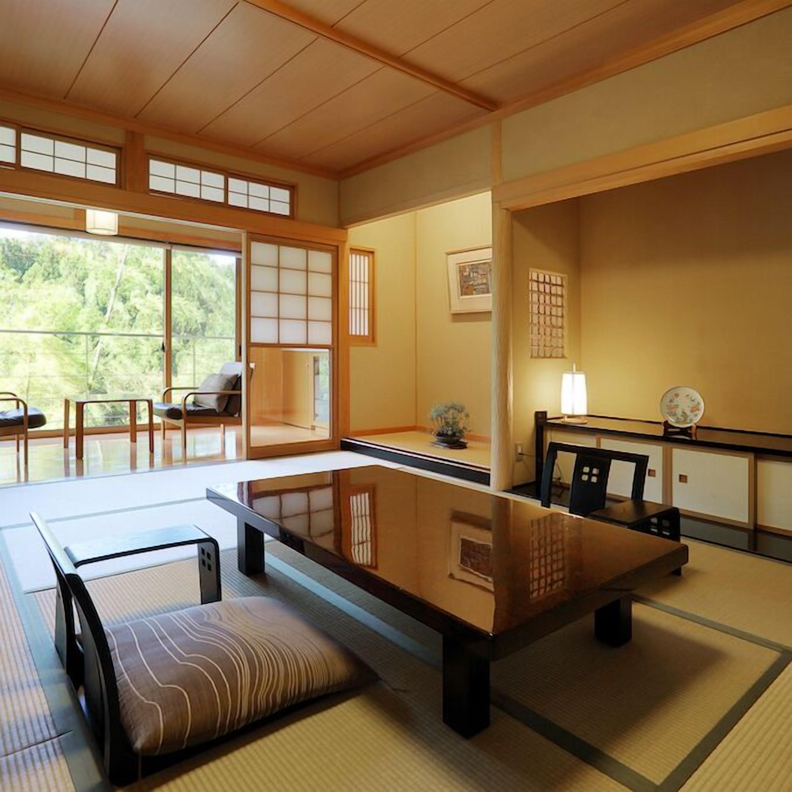 Una habitació japonesa tradicional amb tatamis, una taula baixa, coixins i portes corredisses.