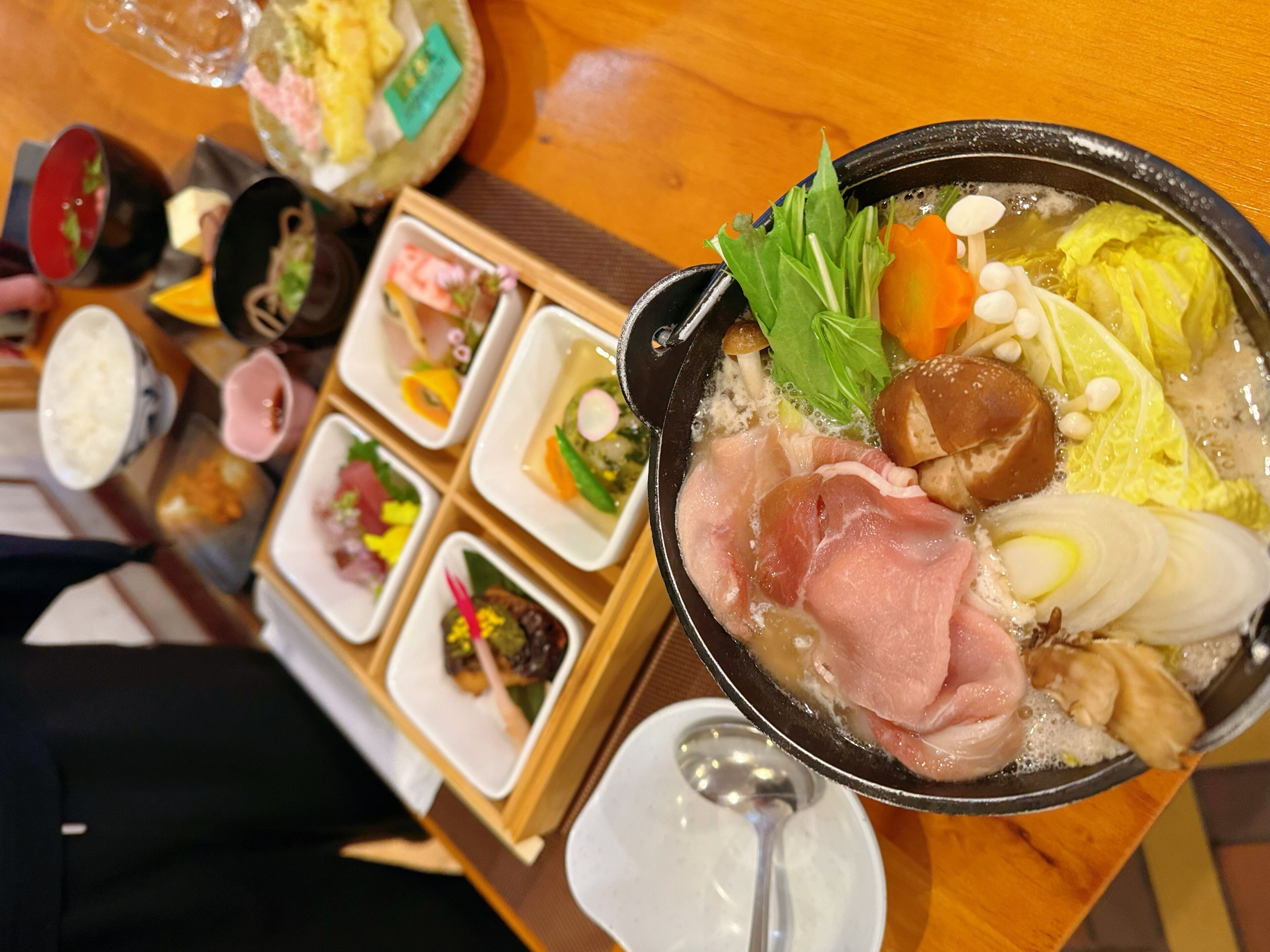Un repas à base de fondue chinoise, avec divers ingrédients et accompagnements.