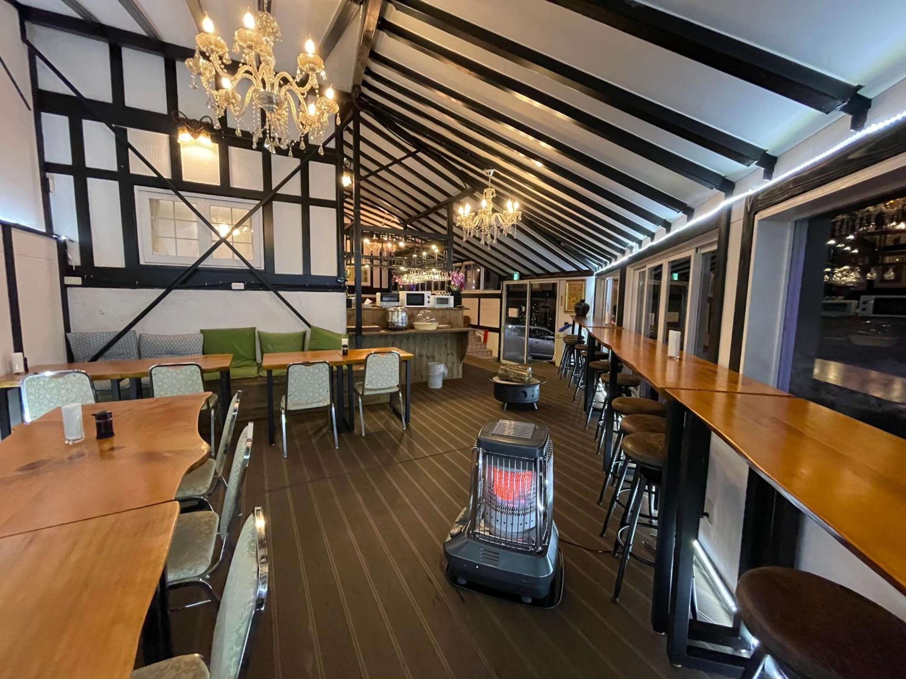A restaurant with exposed wooden beams, a bar area, and a seating arrangement with tables and chairs.