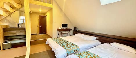 Un dormitorio con dos camas, un escritorio con computadora, una silla y una escalera que lleva a un nivel superior.