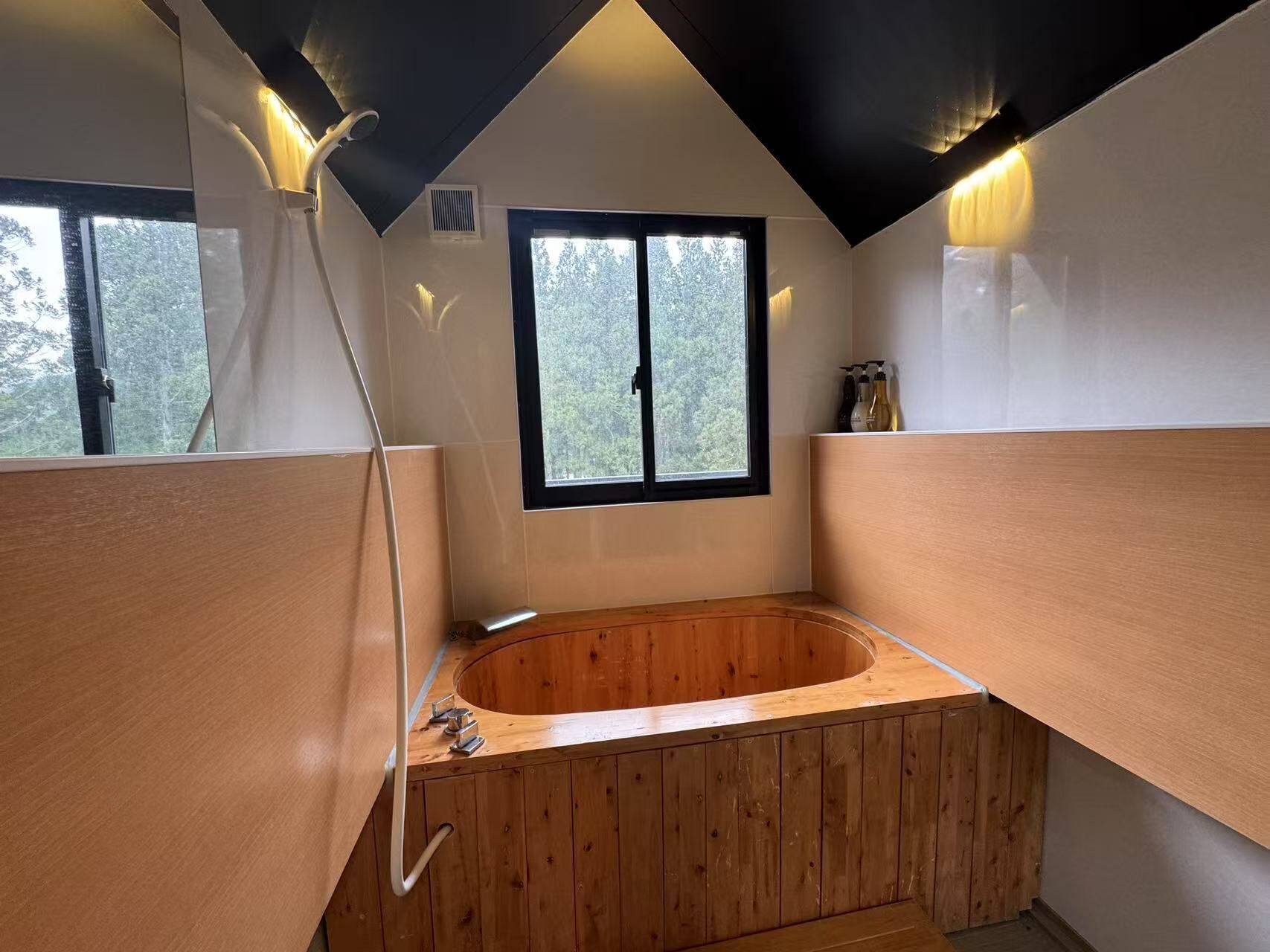 Une salle de bain moderne avec une baignoire en bois, une fenêtre et un espace douche.
