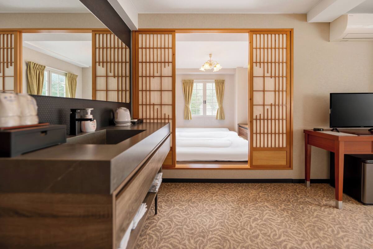 Une chambre d’hôtel avec un lit, un bureau, une télévision et une salle de bain.