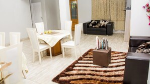 Un salon moderne avec un coin repas, comprenant un canapé, une table basse et un tapis.