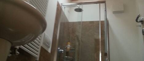 A bathroom with a shower, a sink, and a toilet.