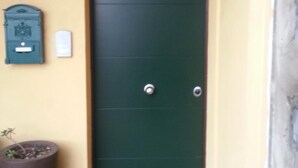 A green door with a number 10 sign above it, a mailbox, and a potted plant beside the door. - Al Piccolo Clarin (Mestre)