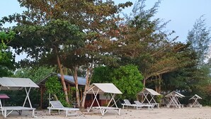 A beachside resort with multiple bungalow-style cabins, each with a small porch and a hammock. - Berakit Bay Resort (Bintan)