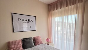 Un lit bien fait, avec des oreillers, une lampe de chevet et un cadre décoratif accroché au mur.