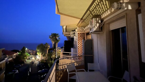 Un balcon avec vue sur l’océan, des meubles d’extérieur et des unités de climatisation.
