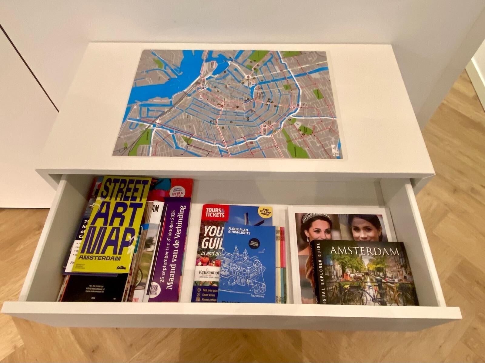 A drawer with a map and travel guides.
