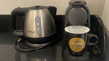 A kitchen area with a Tefal Mini coffee maker and a Magimix coffee machine, both with coffee cups.