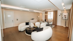 Una sala de estar moderna con sofás blancos, una mesa de centro y un comedor con una mesa y sillas.