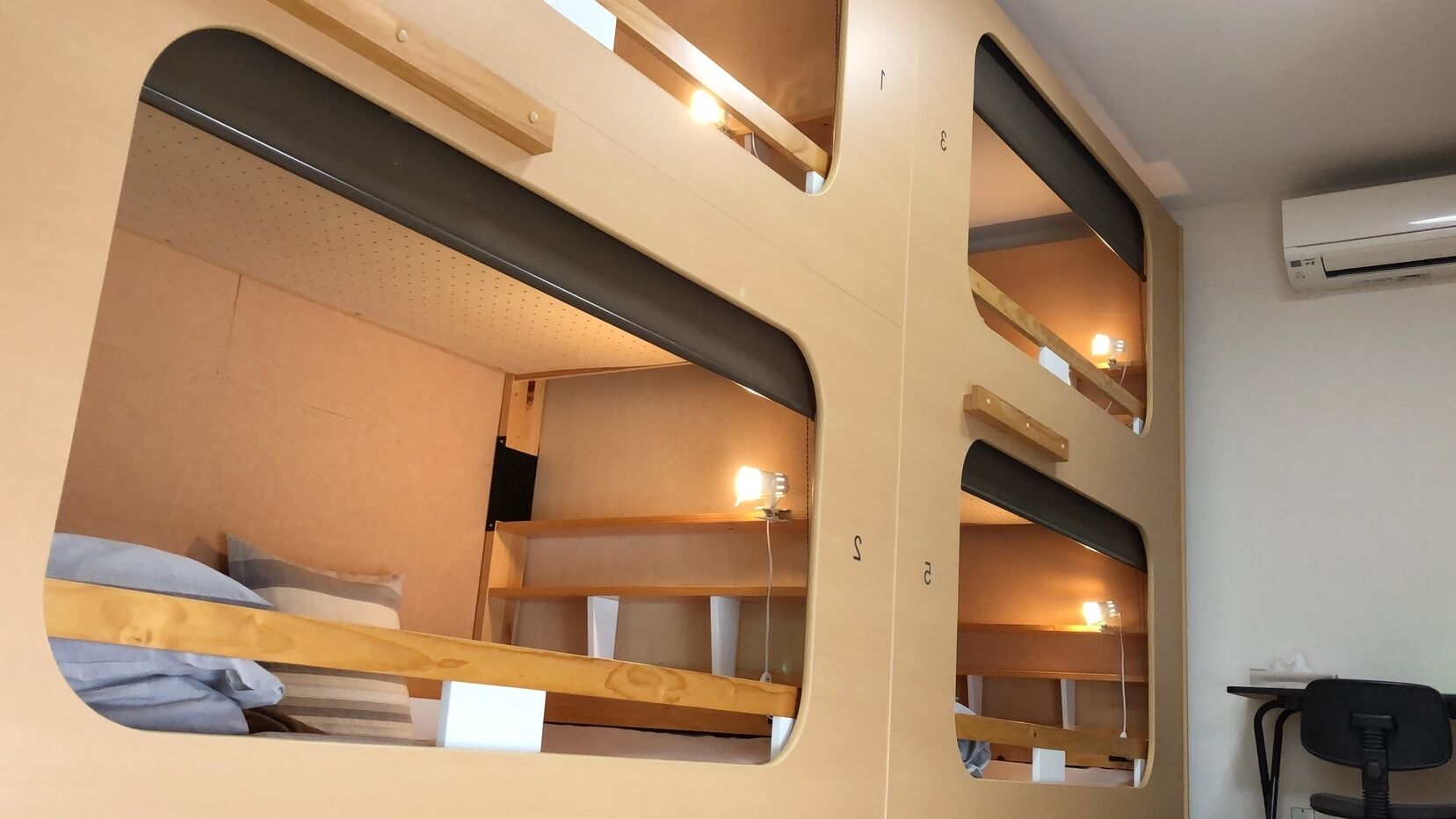 A bunk bed room with a desk and an air conditioner.