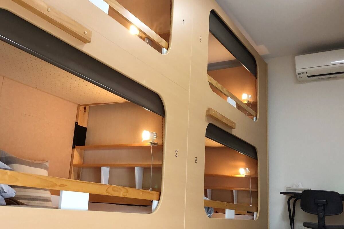 Dormitorio con literas, escritorio y aire acondicionado.