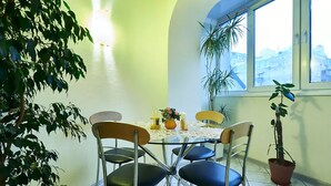 Un coin repas avec une table ronde, quatre chaises et des plantes en pot.