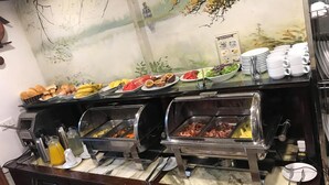 Una mesa de buffet con distintos alimentos y utensilios.