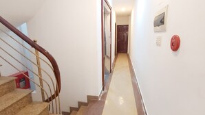 Una escalera con barandilla de madera que lleva a una plataforma. Se ve una caja roja en la plataforma.