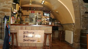 A bar area with a tiled wall, wooden stools, and a sign reading "Utrein Suu Sanhigo".