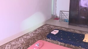 A room with a patterned carpet, a pink bed, a blue bed with a starry pattern, a ceiling fan, and a wardrobe. - Almira Homestay near Airport - Hostel (Jambi)