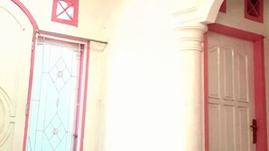 A room with a white door, a window with a metal grille, and a ceiling with recessed lighting. - Almira Homestay near Airport - Hostel (Jambi)