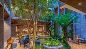An indoor courtyard with a central water feature, seating areas, and lush greenery. - Minh Boutique Hotel & Apartment (Da Nang)