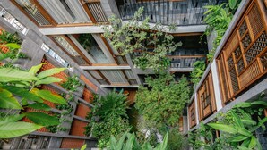 A multi-level building with balconies, wooden railings, and lush greenery. - Minh Boutique Hotel & Apartment (Da Nang)