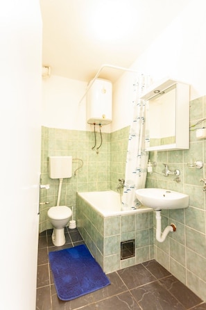 Une salle de bain avec des toilettes, un lavabo et une baignoire.
