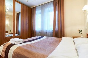 Relax in this serene space with a large bed, a wardrobe, and a mirror.