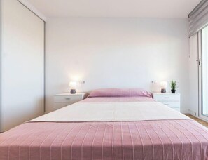 A bedroom with a bed, two bedside tables, and a nightstand. - Apartment Rits by Interhome (Salou)