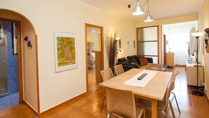 A dining area with a wooden table, wicker chairs, and pendant lighting. - Sardenya - Casp by Interhome (Barcelona)