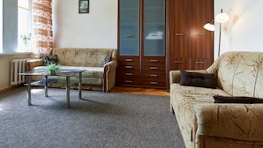 A living room with a sofa, a coffee table, a cabinet, and a lamp. - Home-Hotel Streletskaya 28 (Kyiv)